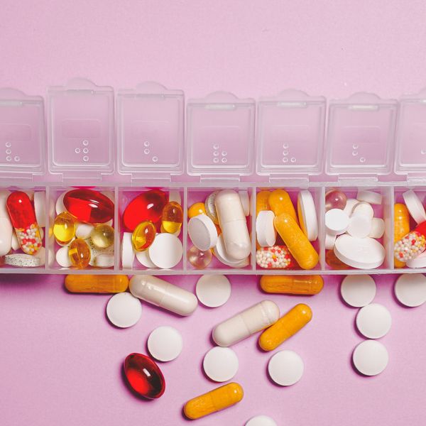 Laboratory test tubes alongside coloured capsules and tablets