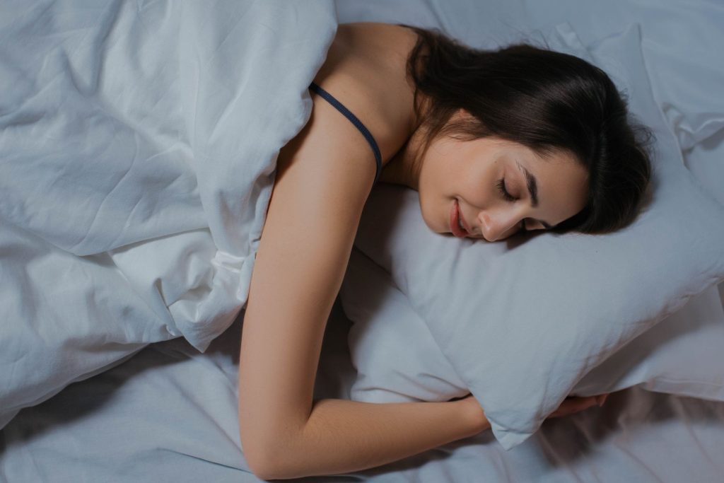 Woman sleeping peacefully in white bedding